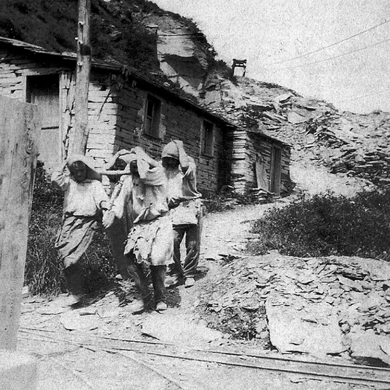 Foto d'epoca che raffigura un trasporto particolare: una lastra di dimensioni fuori dall'ordinario, per il cui trasporto era necessaria la forza di quattro uomini. Collezione Maria Eugenia De Ferrari